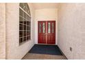Welcoming entryway with striking red double doors and a side window providing natural light at 3684 Miguels Ln, Las Vegas, NV 89120