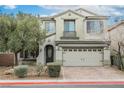 Two-story home with light-colored stucco, landscaped yard, and a brick-paver driveway at 3721 Moonshine Falls Ave, North Las Vegas, NV 89085
