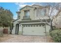 Two-car garage with brick-paver driveway and a small balcony above at 3721 Moonshine Falls Ave, North Las Vegas, NV 89085