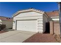 Home's garage with a white door, easy driveway access, and a terra cotta roof at 3761 Tohono Canyon St, Las Vegas, NV 89147