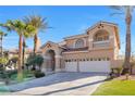 Inviting two-story home with arched entry, tile roof, and a well-manicured lawn at 4024 Mansion Hall Ct, Las Vegas, NV 89129