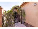 An ornate gate covered with vines leads to the front door at 4125 Gliding Gulls Ave, North Las Vegas, NV 89084