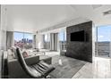 Modern living room with comfortable lounge seating, a mounted television, and views of the city skyline at 4381 W Flamingo Rd # 922, Las Vegas, NV 89103