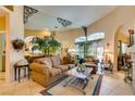 Inviting living room featuring tile floors, arched windows, and an elegant mirror accent at 489 Beaconwood St, Henderson, NV 89052