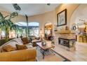 Cozy living room with stone fireplace, tile floors, and an open archway to other rooms at 489 Beaconwood St, Henderson, NV 89052