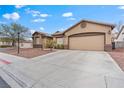 Spacious driveway leading to a two-car garage on a home with a manicured front yard at 5601 Quail Meadow Ct, Las Vegas, NV 89131