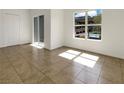 An empty living room featuring tiled floors and a window providing ample light at 7255 W Sunset Rd # 1116, Las Vegas, NV 89113