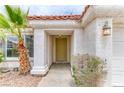 Inviting front entrance with covered porch, textured walls, and a green front door at 7820 Wedlock Ln, Las Vegas, NV 89129