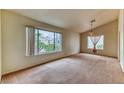 Bright, carpeted living room featuring large windows and neutral tones at 7820 Wedlock Ln, Las Vegas, NV 89129