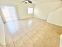 Bright living room features neutral tile flooring and natural light from sliding glass door at 8748 Tomnitz Ave # 103, Las Vegas, NV 89178