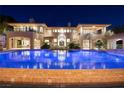 Backyard view highlighting the pool, patio area, and architectural details of the home at twilight at 9801 Orient Express Ct, Las Vegas, NV 89145