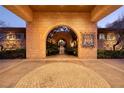 Grand entrance featuring intricate stonework, arched doorway, and well-manicured landscaping at 9801 Orient Express Ct, Las Vegas, NV 89145