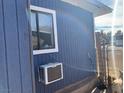 A view of the side exterior showing blue wood siding and an AC unit at 11 Magnesium St, Henderson, NV 89015