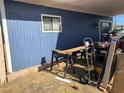 An exterior view of the side of the home showing blue wood siding and tools at 11 Magnesium St, Henderson, NV 89015
