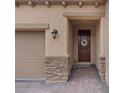 Inviting front entryway with stone accents, a decorative wreath and brick paved driveway at 1269 Olivia Pkwy, Henderson, NV 89011