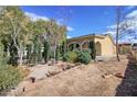 A well-maintained single-story home featuring a stucco exterior and mature trees at 1413 Culley St, Las Vegas, NV 89110