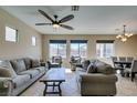 Spacious living room featuring large windows, neutral paint, ceiling fan, and comfortable seating at 1609 Danielle Rebecca Ave, North Las Vegas, NV 89086