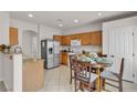 Open kitchen with stainless steel appliances and wooden cabinetry, adjacent to dining area at 2572 Favorable Pointe Ct, Henderson, NV 89052