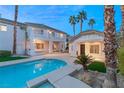 Backyard oasis with a shimmering pool, mature palms, and a charming guesthouse, perfect for entertaining at 2694 Caumsett Ct, Las Vegas, NV 89117