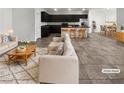 Bright, staged living room with modern furniture, open to the kitchen and dining areas at 3726 Shaving Shadows Ave, North Las Vegas, NV 89032