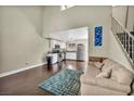 Bright living room with vaulted ceilings, wood floors, staircase and view to kitchen at 5157 Garden Ln # F, Las Vegas, NV 89119
