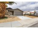 Charming single-story home with a two-car garage, desert landscaping, and a well-maintained front yard at 5832 Arandas Ct, Las Vegas, NV 89103