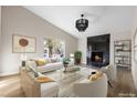 Bright living room with a fireplace, large window, modern lighting, and hardwood floors at 5832 Arandas Ct, Las Vegas, NV 89103