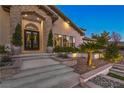 Grand entrance with a stone archway, double doors, and meticulously landscaped garden beds at 6 Ayden Dr, Henderson, NV 89052
