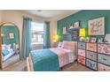 Cozy bedroom with a single bed, colorful decor, and a large mirror at 6920 Lynbridge St # 49, Las Vegas, NV 89166