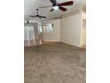 Spacious living room featuring neutral carpet, ceiling fans, and ample natural light at 807 Airy Hill St, Henderson, NV 89015