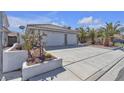 Exterior view of a single-Gathering home with a two-car garage, desert landscaping and well maintained driveway at 897 Cavaison Ave, Las Vegas, NV 89123