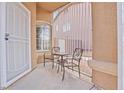 Private front courtyard area featuring neutral stucco walls, security gate, and a seating area at 9031 W Viking Rd, Las Vegas, NV 89147