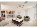 Bright, open living room featuring stylish furniture, ceiling fan and seamless flow into the kitchen at 11125 Twilight Times Ct, Las Vegas, NV 89135