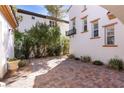 Private outdoor patio with brick pavers and lush greenery, perfect for relaxation and entertaining at 11775 Woodbrook Ct, Las Vegas, NV 89141