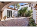 Charming outdoor patio featuring brick pavers, verdant landscaping, and serene architectural details at 11775 Woodbrook Ct, Las Vegas, NV 89141