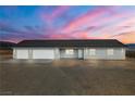 Single-story home featuring multiple garages and easy care landscaping at 1330 W Gee St, Pahrump, NV 89060