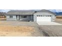 Well-maintained home featuring a large garage and desert landscaping at 1330 W Gee St, Pahrump, NV 89060
