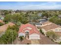 An aerial view showcases a red-tiled roof home nestled in a lush, green neighborhood with city views at 2008 Hobbyhorse Ave, Henderson, NV 89012