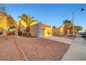 Exterior shot of charming home featuring an attached garage, desert landscaping, and a mature palm tree at 3152 Centavo Dr, Las Vegas, NV 89117