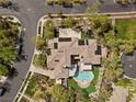 An aerial view shows the pool, patio, multiple roof lines and surrounding landscaping at 3680 Belvedere Park Ln, Las Vegas, NV 89141