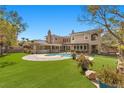 Beautiful backyard featuring a pool, turf area and covered patio at 3680 Belvedere Park Ln, Las Vegas, NV 89141