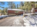 Exterior view of charming home with stone foundation and driveway, surrounded by snowy landscape at 4165 Mont Blanc Way, Mount Charleston, NV 89124