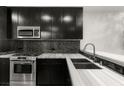 Close-up of kitchen boasting stainless appliances, gray backsplash and marble counter at 4525 Dean Martin Dr # 511, Las Vegas, NV 89103