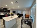 Open-concept living area with modern kitchen island, dark cabinets, and plenty of natural light at 4924 Chidlaw Ave # 3, Las Vegas, NV 89115