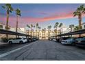 Exterior shot of condo buildings with covered parking and palm trees at sunset at 5000 Red Rock St # 120, Las Vegas, NV 89118