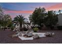 Exterior of a condo building and decorative rocks at dusk at 5000 Red Rock St # 120, Las Vegas, NV 89118