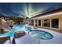 Resort-style backyard pool with water slide, hot tub, and covered outdoor living space create a perfect oasis at 5870 N Durango Dr, Las Vegas, NV 89149