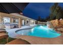 Backyard pool with a waterfall, spa, and covered lounge area, perfect for relaxation at 5870 N Durango Dr, Las Vegas, NV 89149