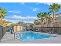 Community pool with lounge chairs, palm trees, and a small changing cabana at 6110 Scarlet Leaf St, Las Vegas, NV 89148