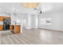 Spacious living room and kitchen area with modern lighting and laminate flooring at 6329 Sandy Ridge St # 1, North Las Vegas, NV 89081